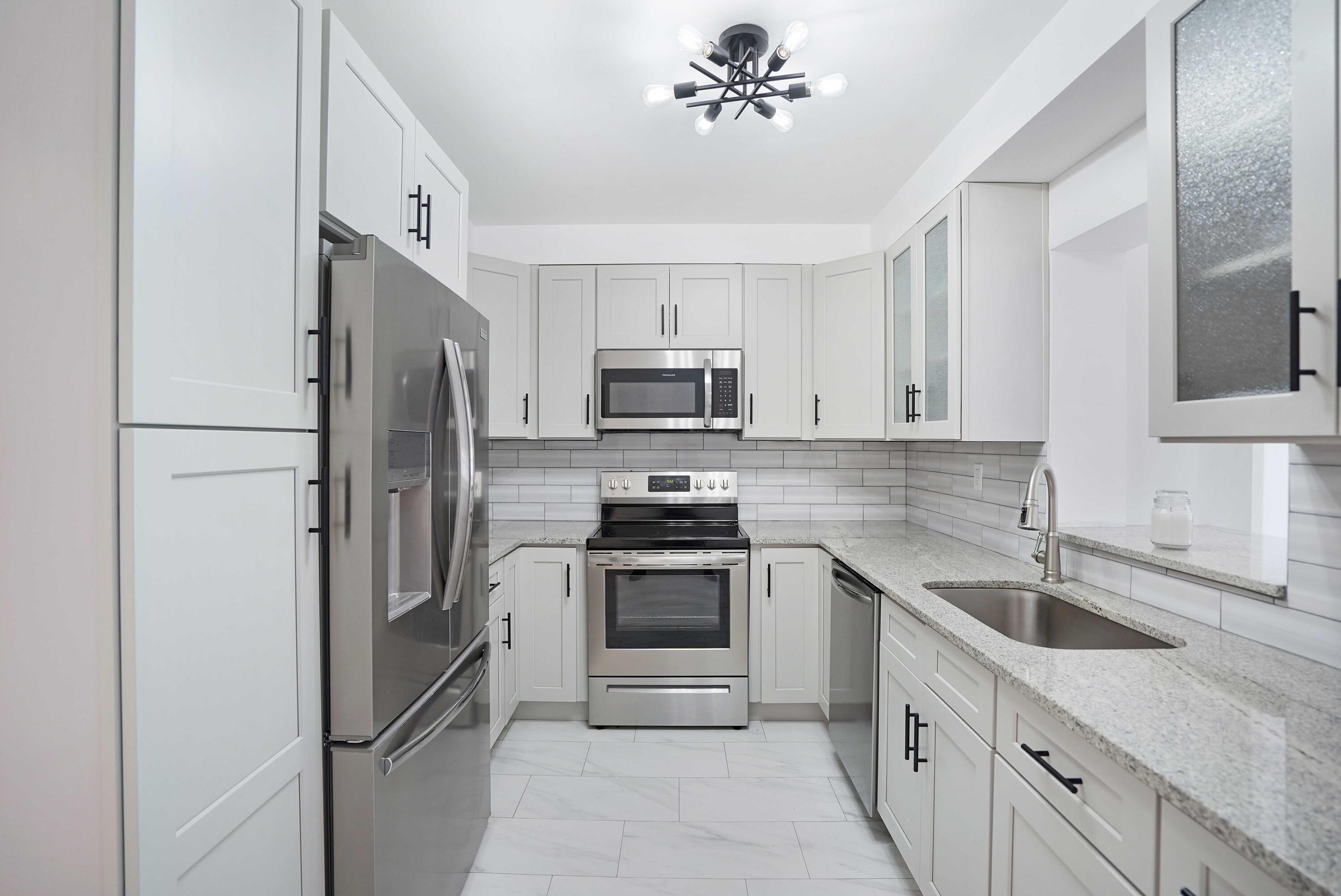 5100 Northeast 22nd Avenue Lighthouse Point, FL 33064 - Photo 24 of 31 a kitchen with stainless steel appliances granite countertop a refrigerator stove and sink