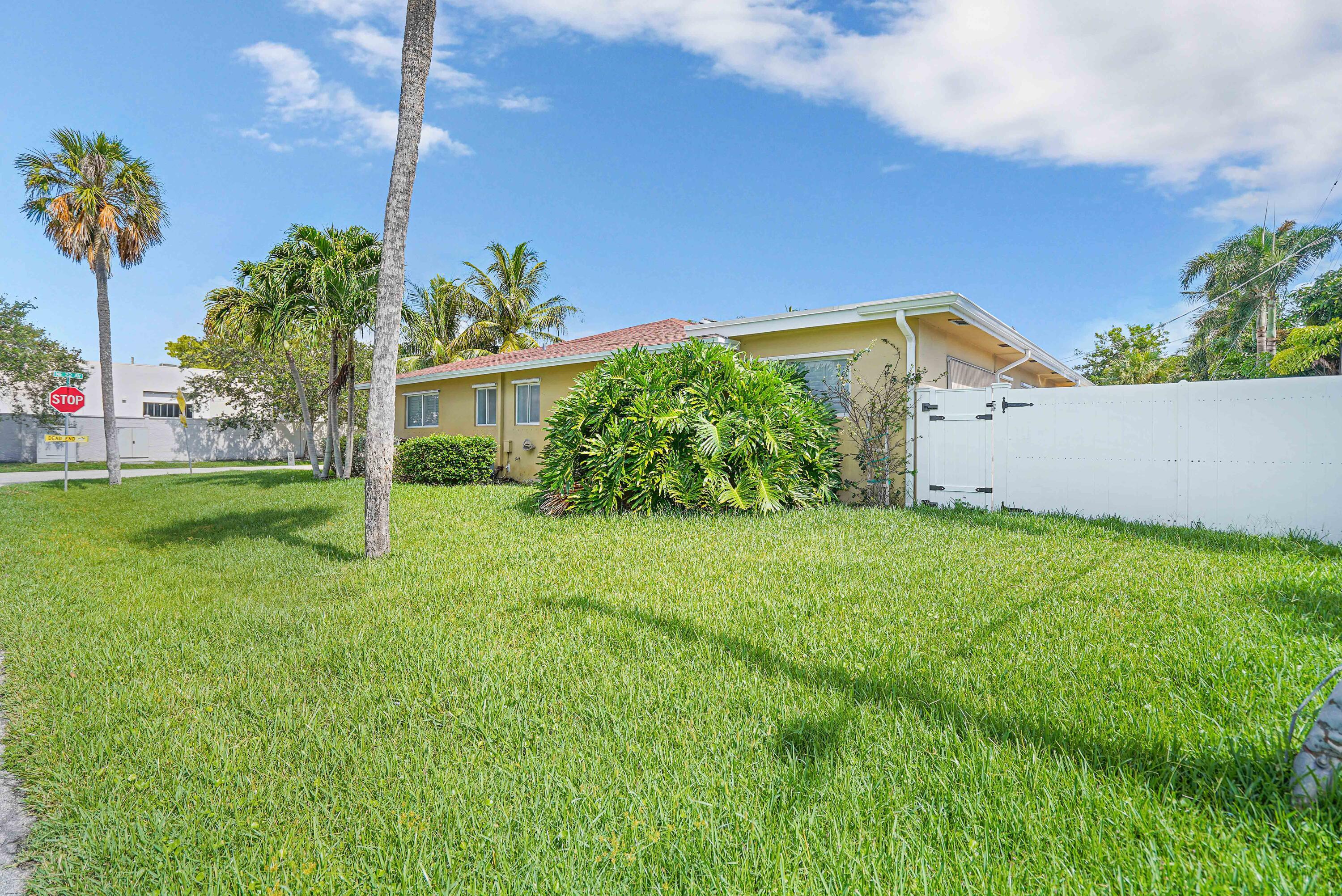 5100 Northeast 22nd Avenue Lighthouse Point, FL 33064 - Photo 3 of 31 a front view of a house with garden