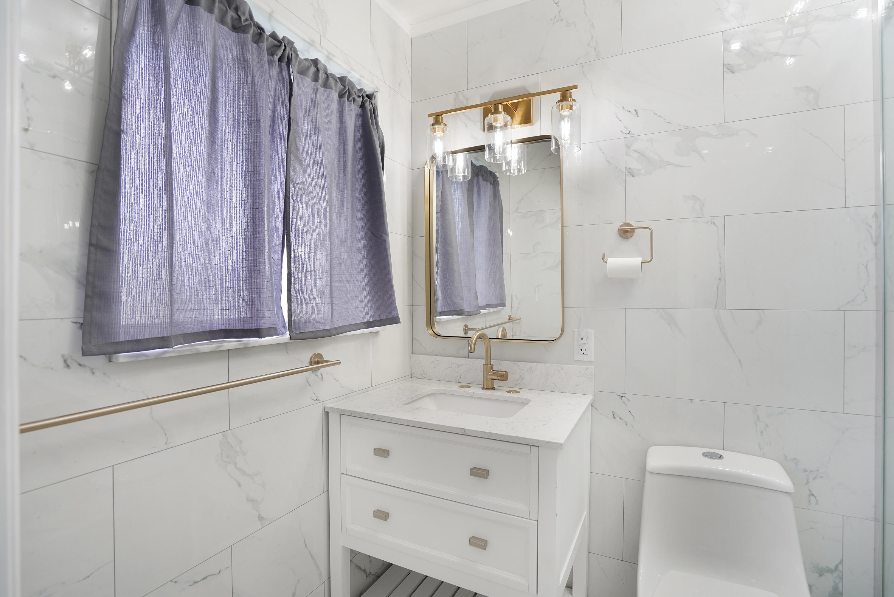 5100 Northeast 22nd Avenue Lighthouse Point, FL 33064 - Photo 5 of 31 a bathroom with a sink a mirror and a shower