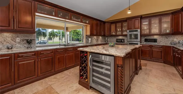 a kitchen with stainless steel appliances granite countertop wooden cabinets sink and a stove