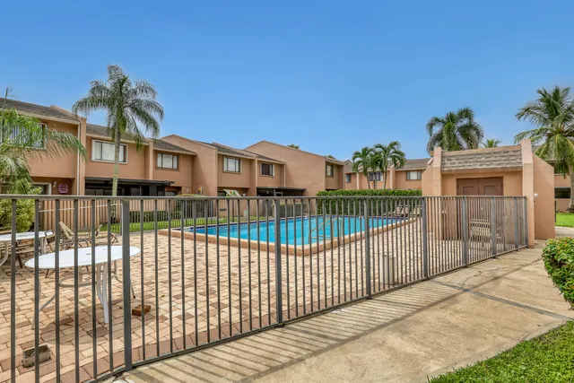 a view of swimming pool with outdoor seating and house in the background
