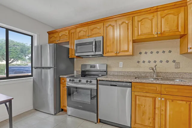 a kitchen with stainless steel appliances granite countertop a sink and cabinets