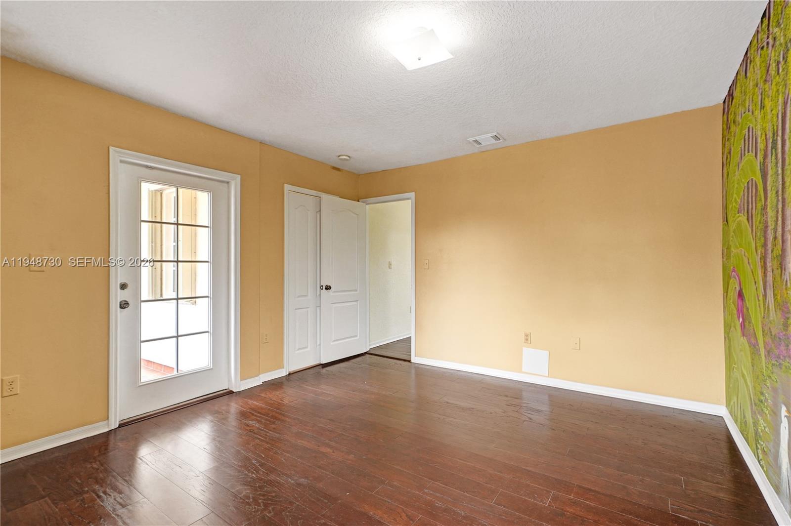 5502 Southwest 162nd Place Miami, FL 33185 - Photo 48 of 72 a view of an empty room with wooden floor and a window