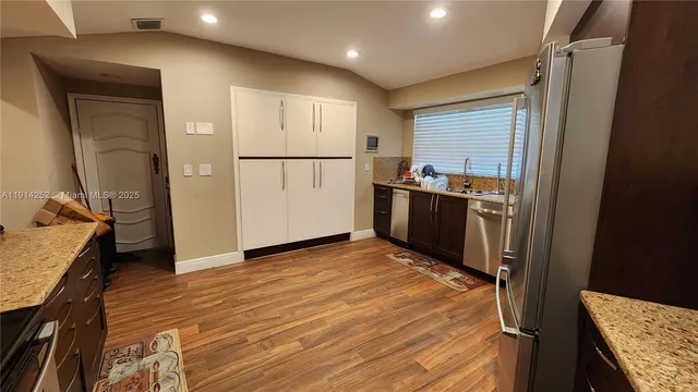 a kitchen with granite countertop stainless steel appliances and wooden cabinets