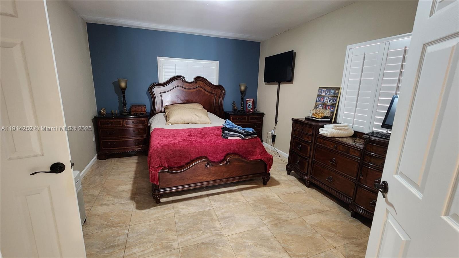 7945 Sunset Drive Miami, FL 33143 - Photo 5 of 28 a bedroom with a bed and a flat screen tv