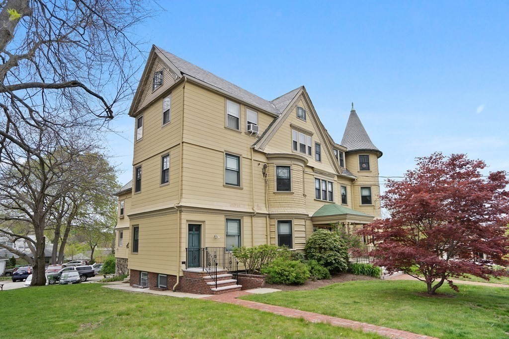 49-53 Appleton Street, Unit 7 Arlington, MA 02476 - Photo 20 of 21 a view of a white house with a big yard and large trees