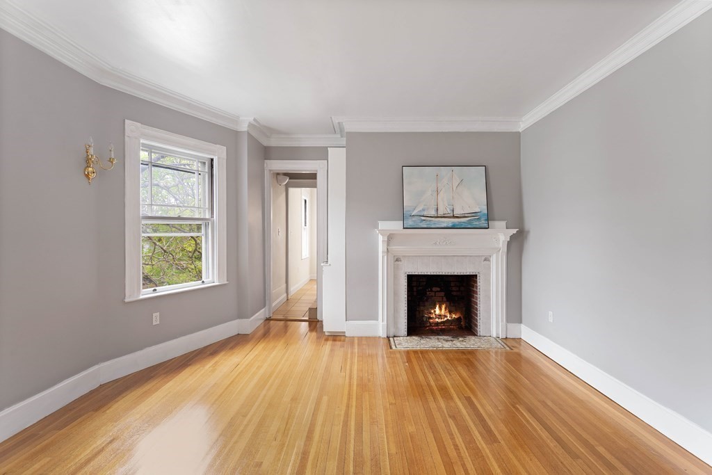 49-53 Appleton Street, Unit 7 Arlington, MA 02476 - Photo 2 of 21 a view of an empty room with wooden floor fireplace and a window