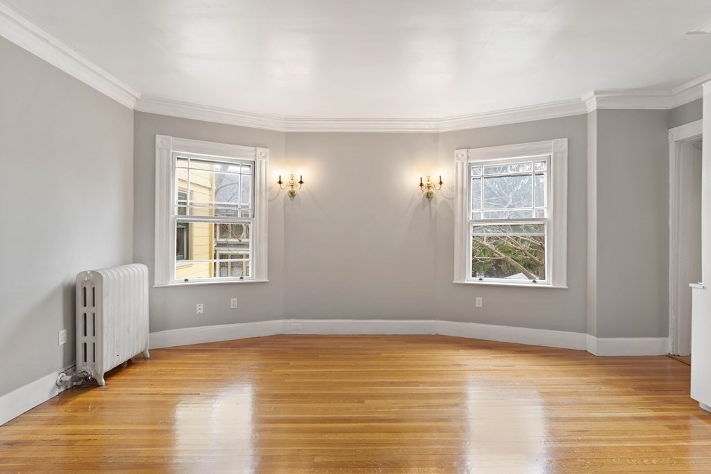 49-53 Appleton Street, Unit 7 Arlington, MA 02476 - Photo 4 of 21 a view of an empty room with window and wooden floor