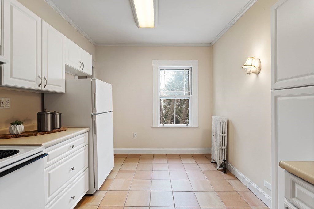 49-53 Appleton Street, Unit 7 Arlington, MA 02476 - Photo 7 of 21 a kitchen with white cabinets and white appliances