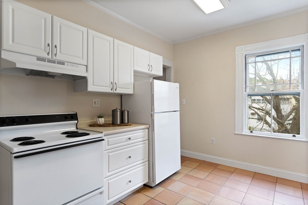 49-53 Appleton Street, Unit 7 Arlington, MA 02476 - Photo 10 of 21 a kitchen with cabinets appliances a sink and a window