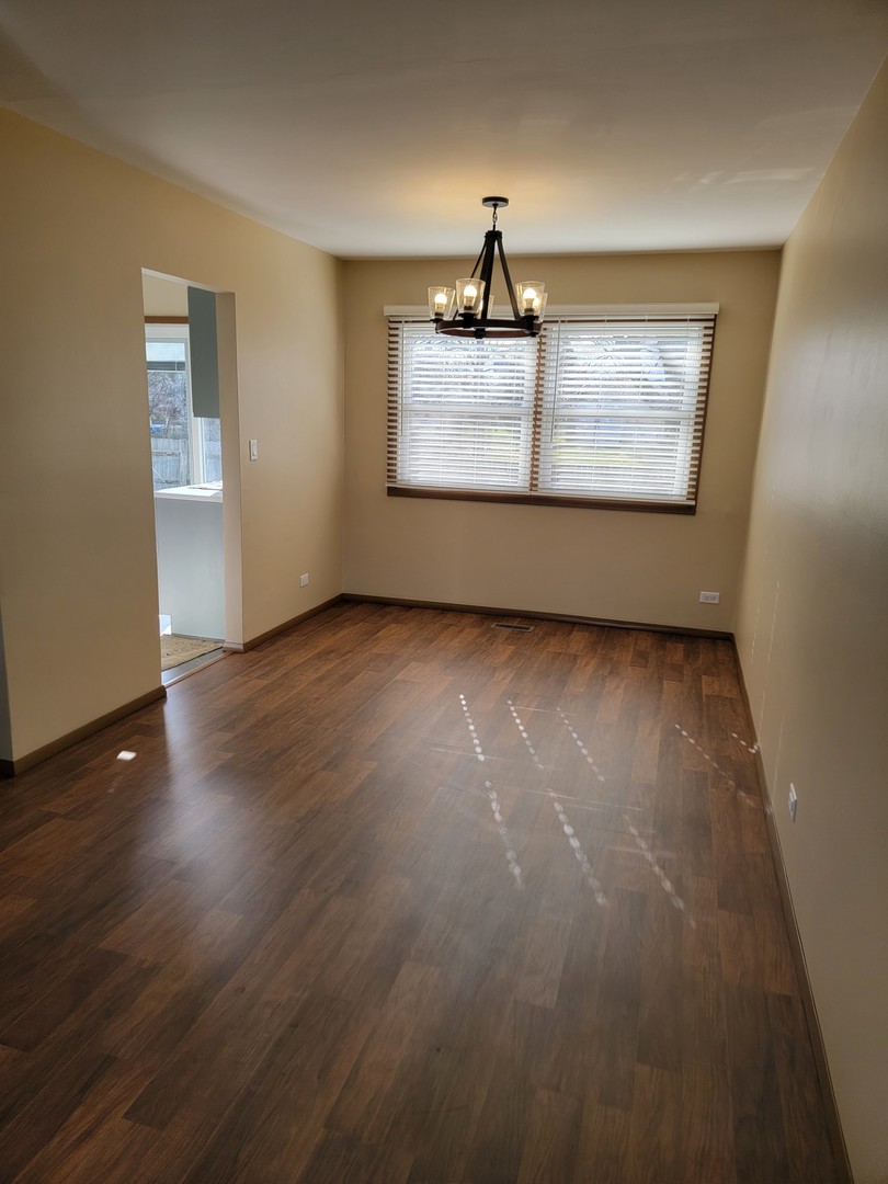 313 Dean Circle Bolingbrook, IL 60440 - Photo 5 of 15 an empty room with wooden floor cabinet and windows