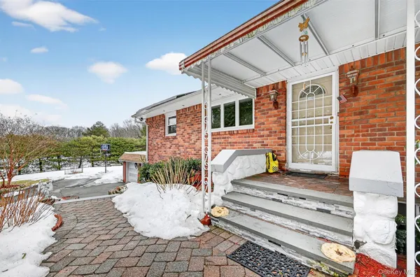 a front view of house with yard and trees in the background