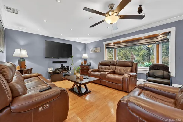 a open kitchen with stainless steel appliances granite countertop a sink a stove a dining table and chairs with wooden floor