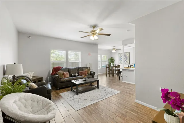 a living room with furniture a flat screen tv and a window