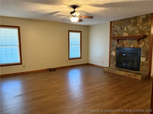 wooden floor fireplace and window in an empty room