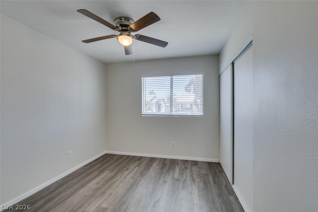 2028 Rustler Ridge Avenue North Las Vegas, NV 89031 - Photo 26 of 40 Wood-look flooring and a window with blinds define this tranquil room, offering a blank canvas for personalization.