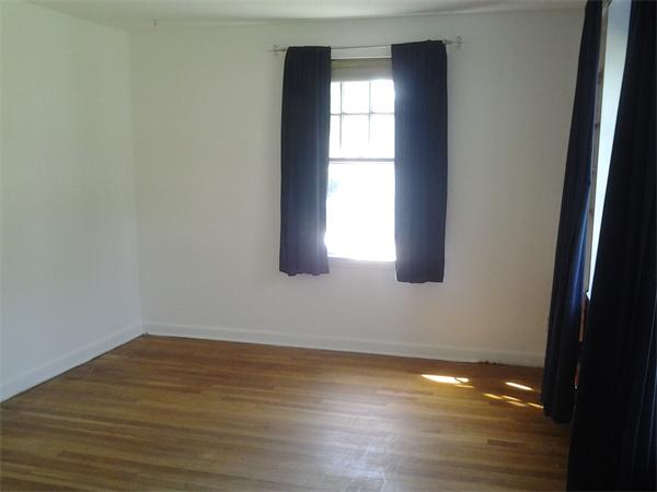 161 Mayflower Road Springfield, MA 01118 - Photo 12 of 20 a view of an empty room with wooden floor and a window