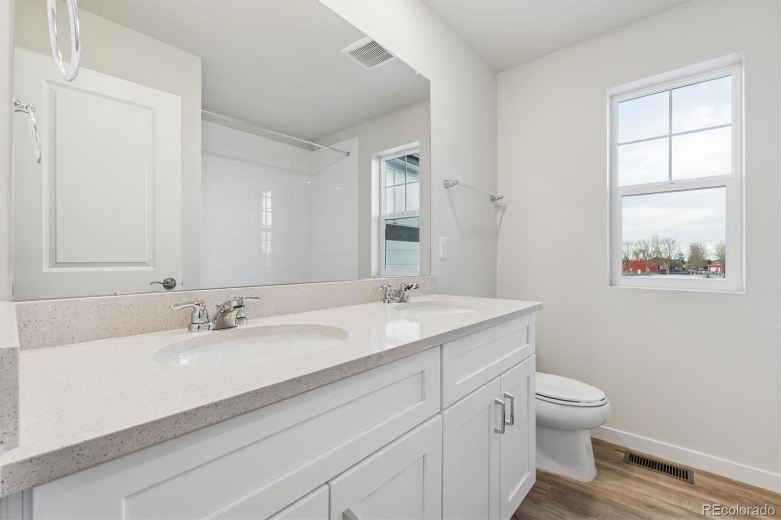 1430 Farmstead Street Brighton, CO 80601 - Photo 16 of 24 a bathroom with a granite countertop sink a toilet and a mirror