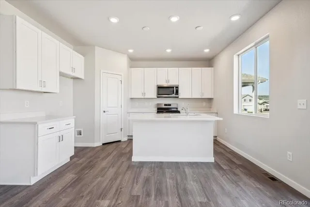 a kitchen with granite countertop white cabinets and white appliances