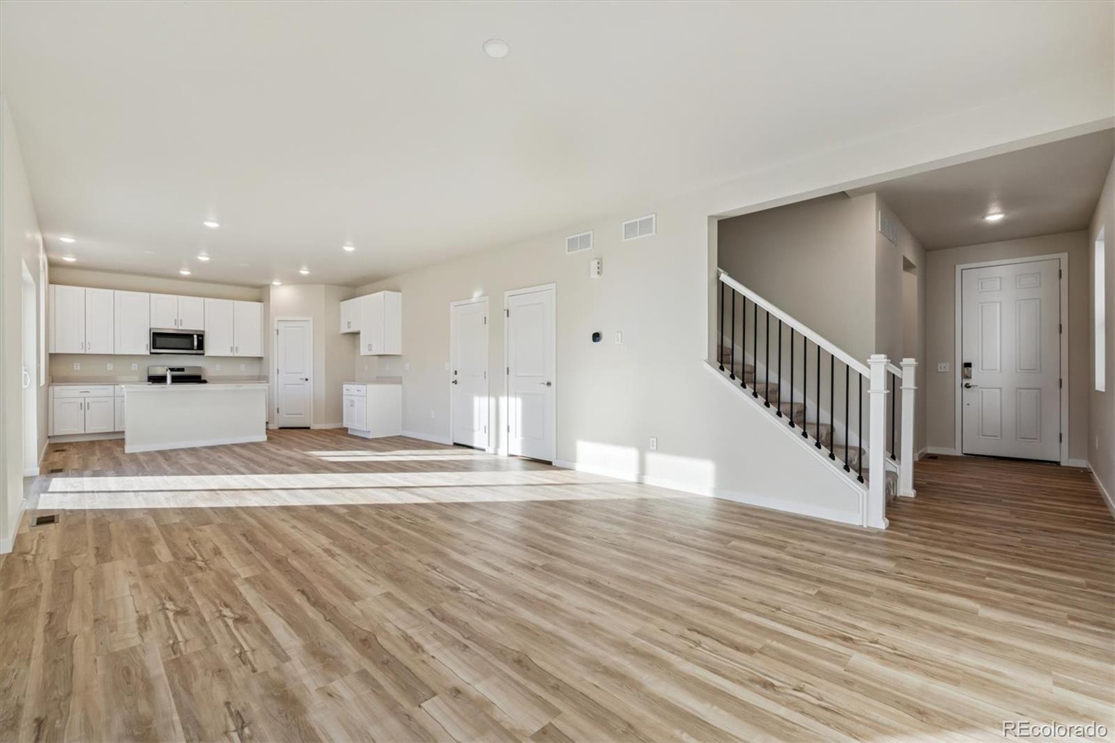 1430 Farmstead Street Brighton, CO 80601 - Photo 3 of 24 a view of large kitchen with wooden floor and windows