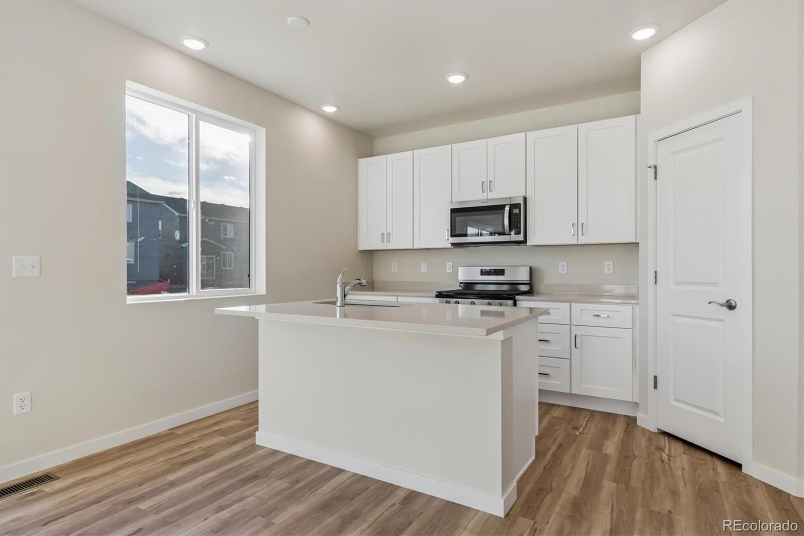 1430 Farmstead Street Brighton, CO 80601 - Photo 6 of 24 a kitchen with stainless steel appliances granite countertop a stove a sink and a microwave