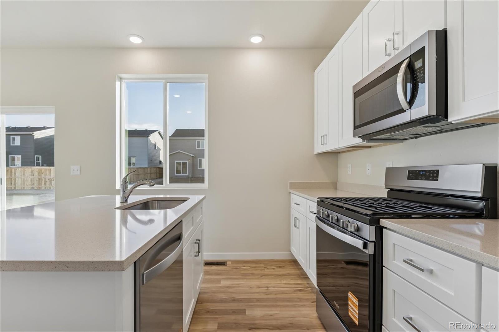 1430 Farmstead Street Brighton, CO 80601 - Photo 9 of 24 a kitchen with stainless steel appliances granite countertop a sink and a stove