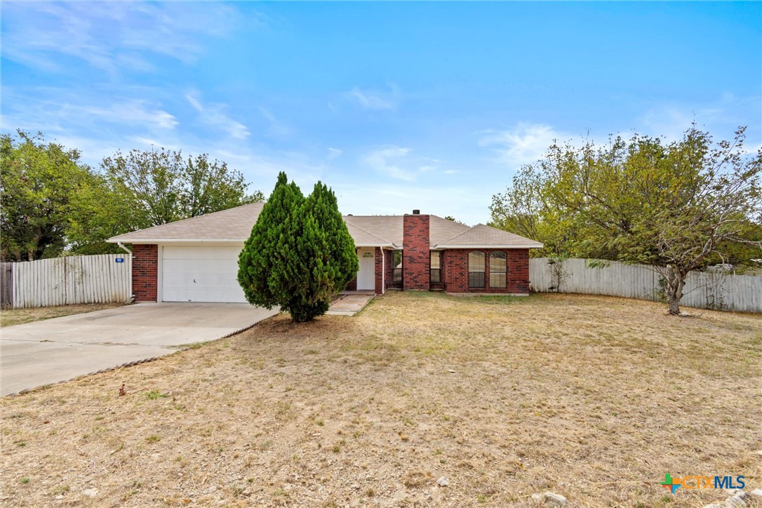 a tall house with a large tree and yard in front of it