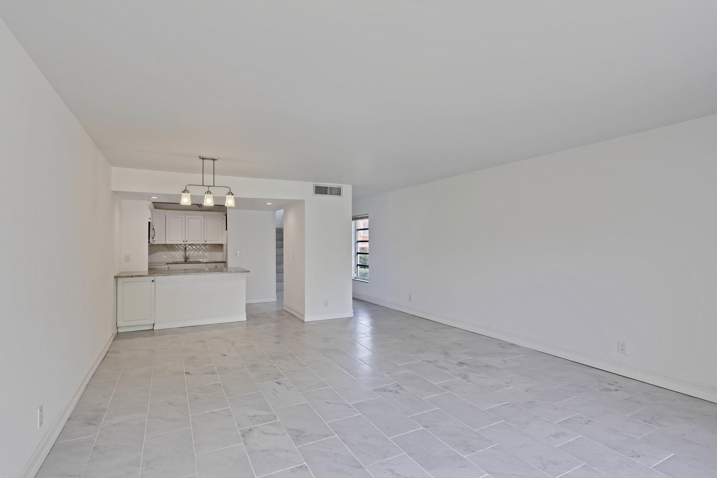 394 Golfview Road, Unit F North Palm Beach, FL 33408 - Photo 12 of 73 a large white kitchen with white cabinets and a stove