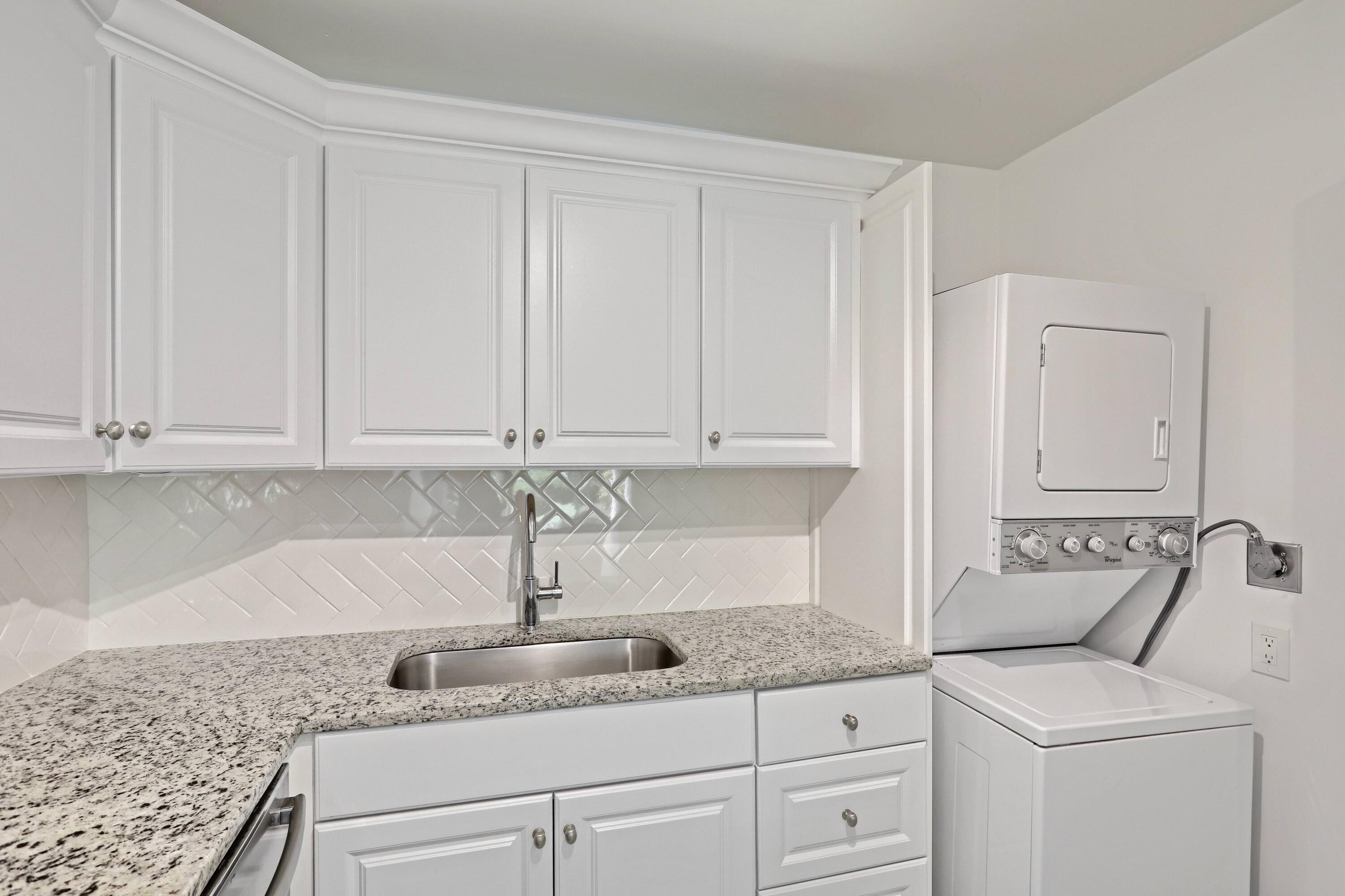 394 Golfview Road, Unit F North Palm Beach, FL 33408 - Photo 19 of 73 a kitchen with granite countertop white cabinets and white appliances