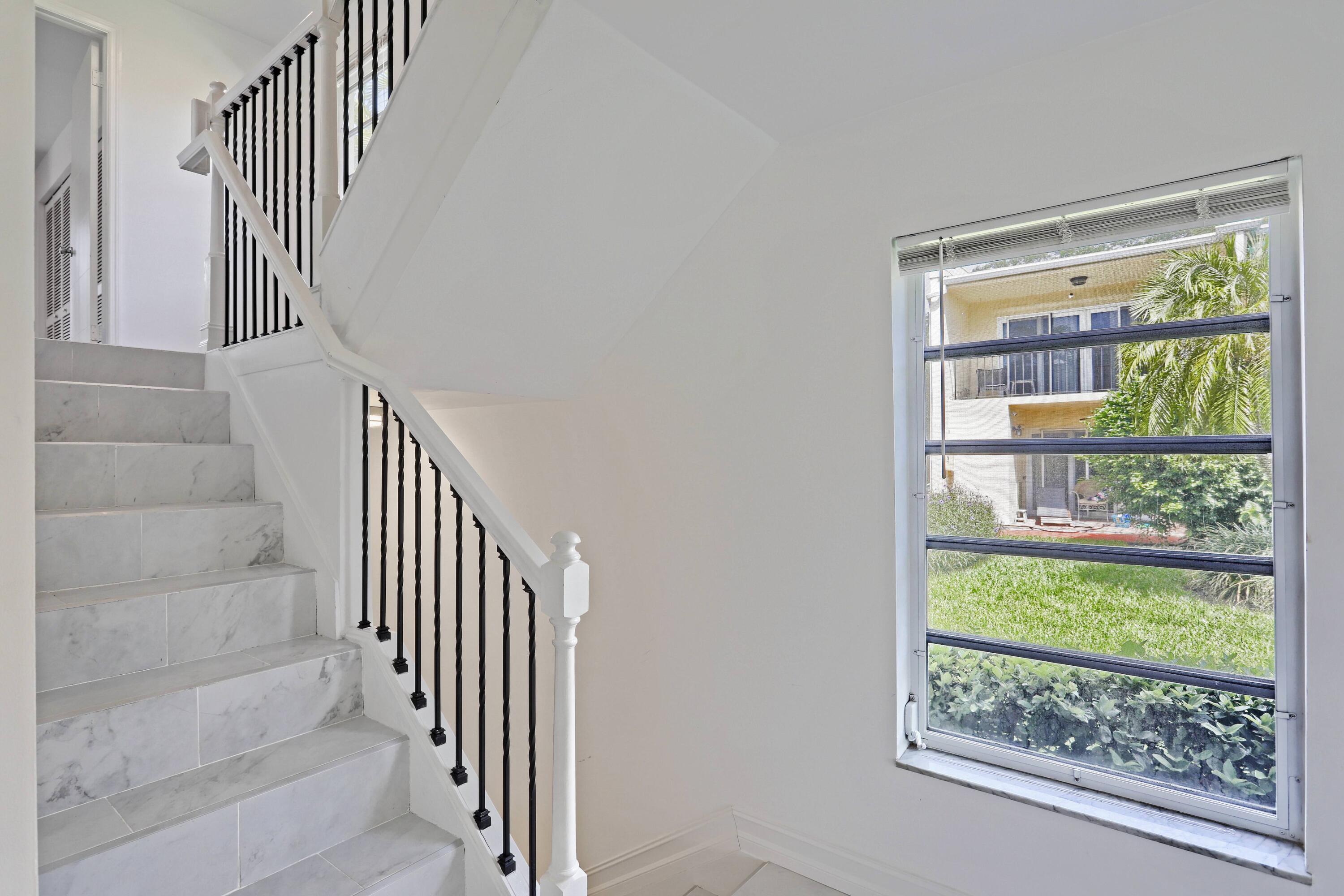 394 Golfview Road, Unit F North Palm Beach, FL 33408 - Photo 21 of 73 a view of staircase with wooden floor and a floor to ceiling window