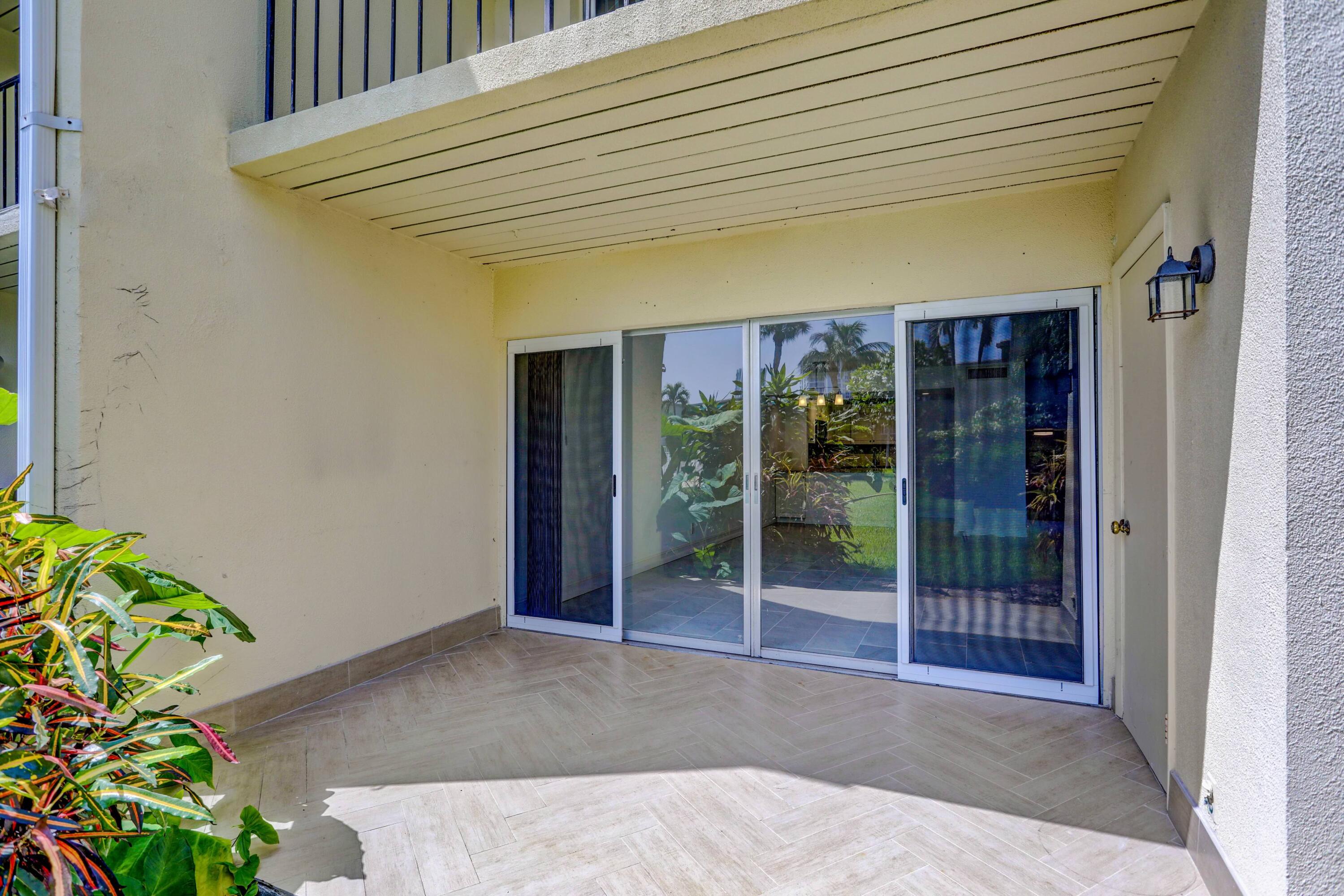 394 Golfview Road, Unit F North Palm Beach, FL 33408 - Photo 39 of 73 a view of a house with a potted plant and floor to ceiling window