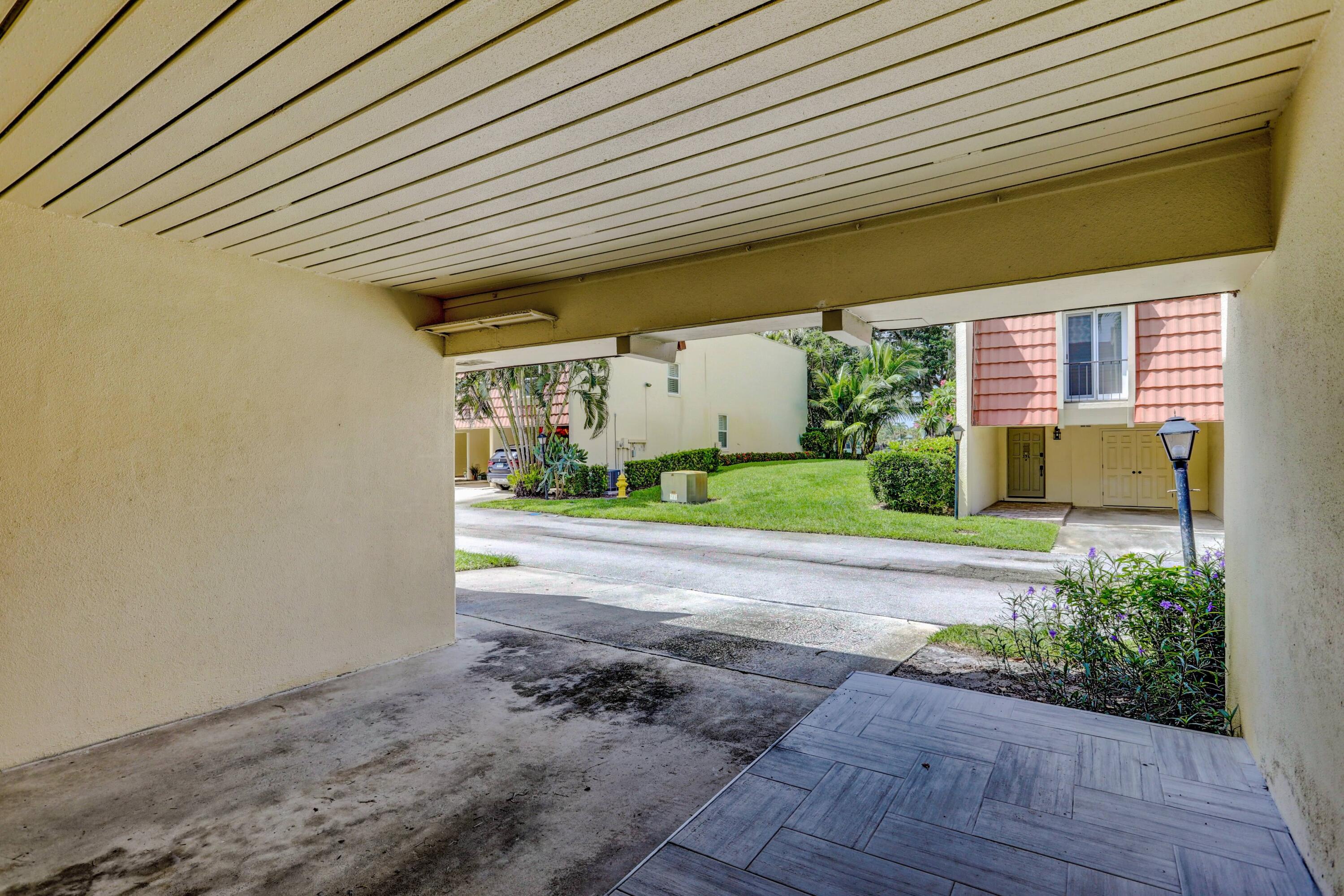 394 Golfview Road, Unit F North Palm Beach, FL 33408 - Photo 7 of 73 a front view of a house with a yard and a garage