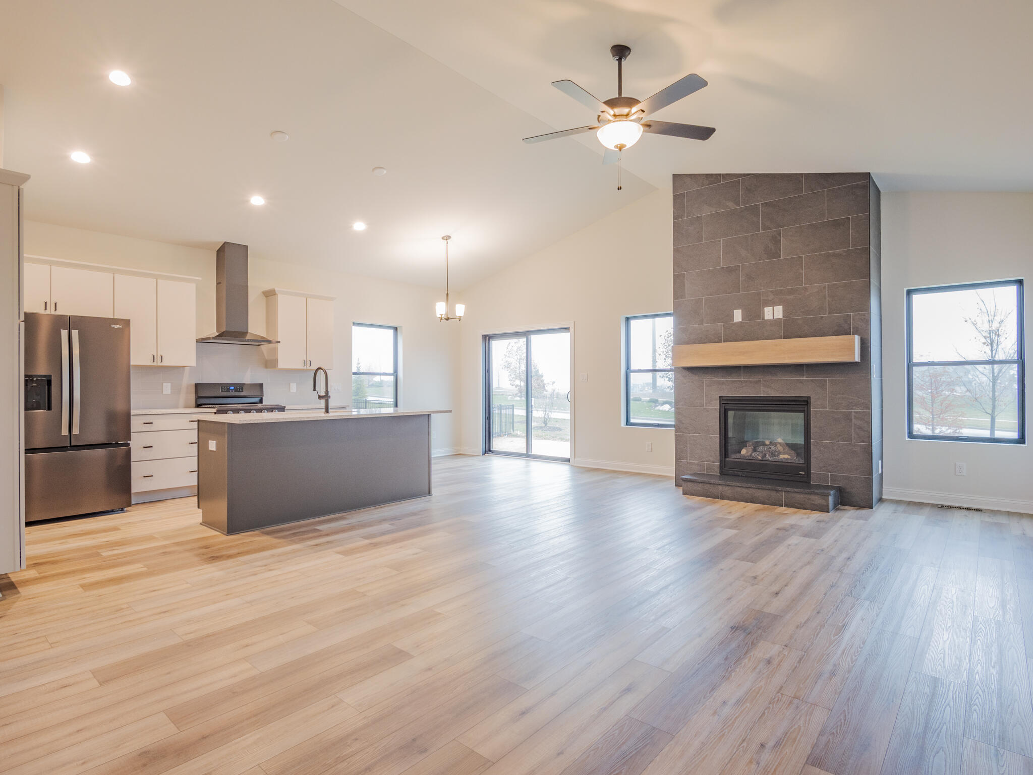3004 Forestside Lane Valparaiso, IN 46385 - Photo 8 of 23 a view of kitchen with granite countertop a stove top oven a sink dishwasher and a fireplace with wooden floor