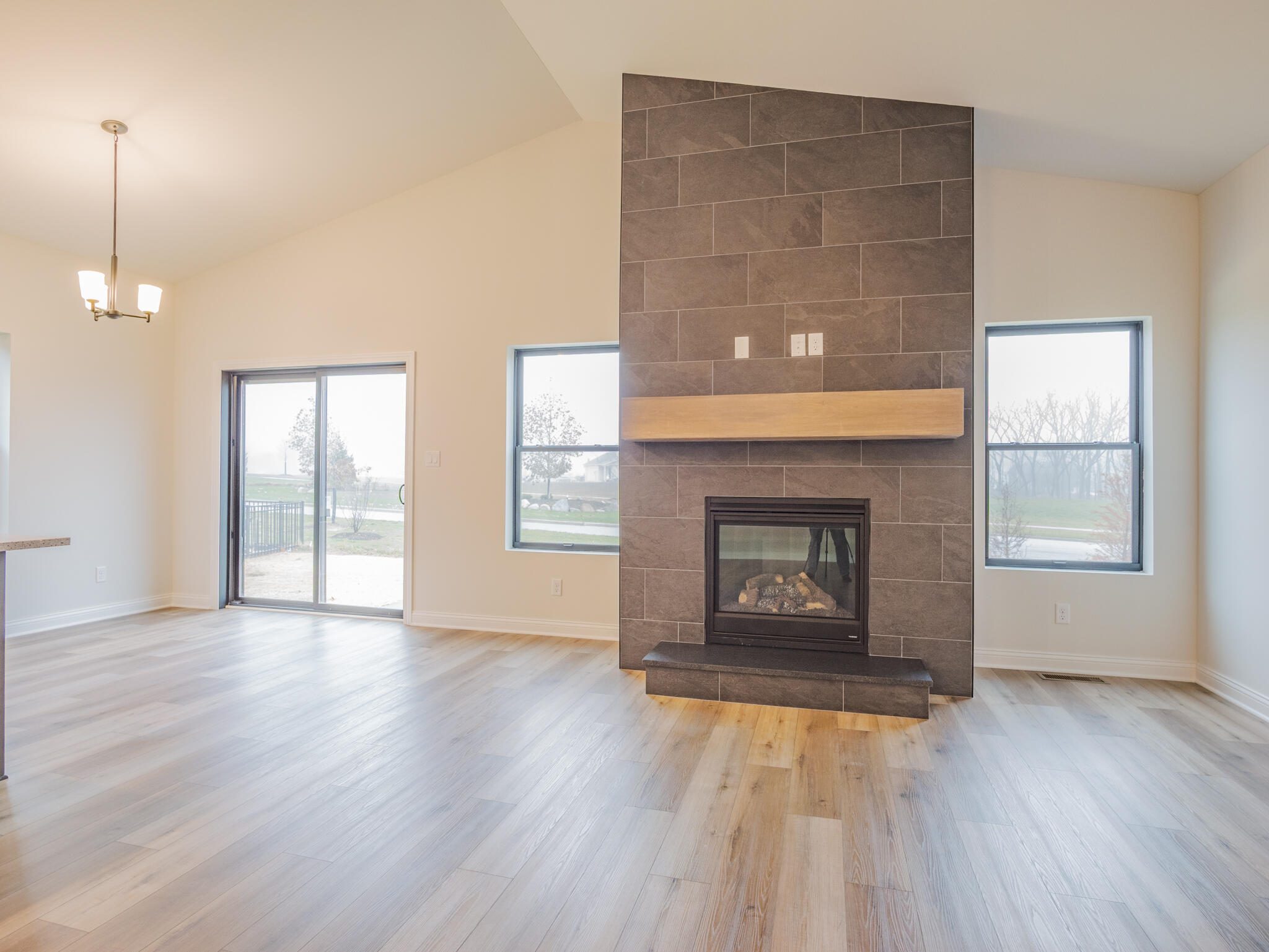 3004 Forestside Lane Valparaiso, IN 46385 - Photo 9 of 23 an empty room with wooden floor fireplace and windows