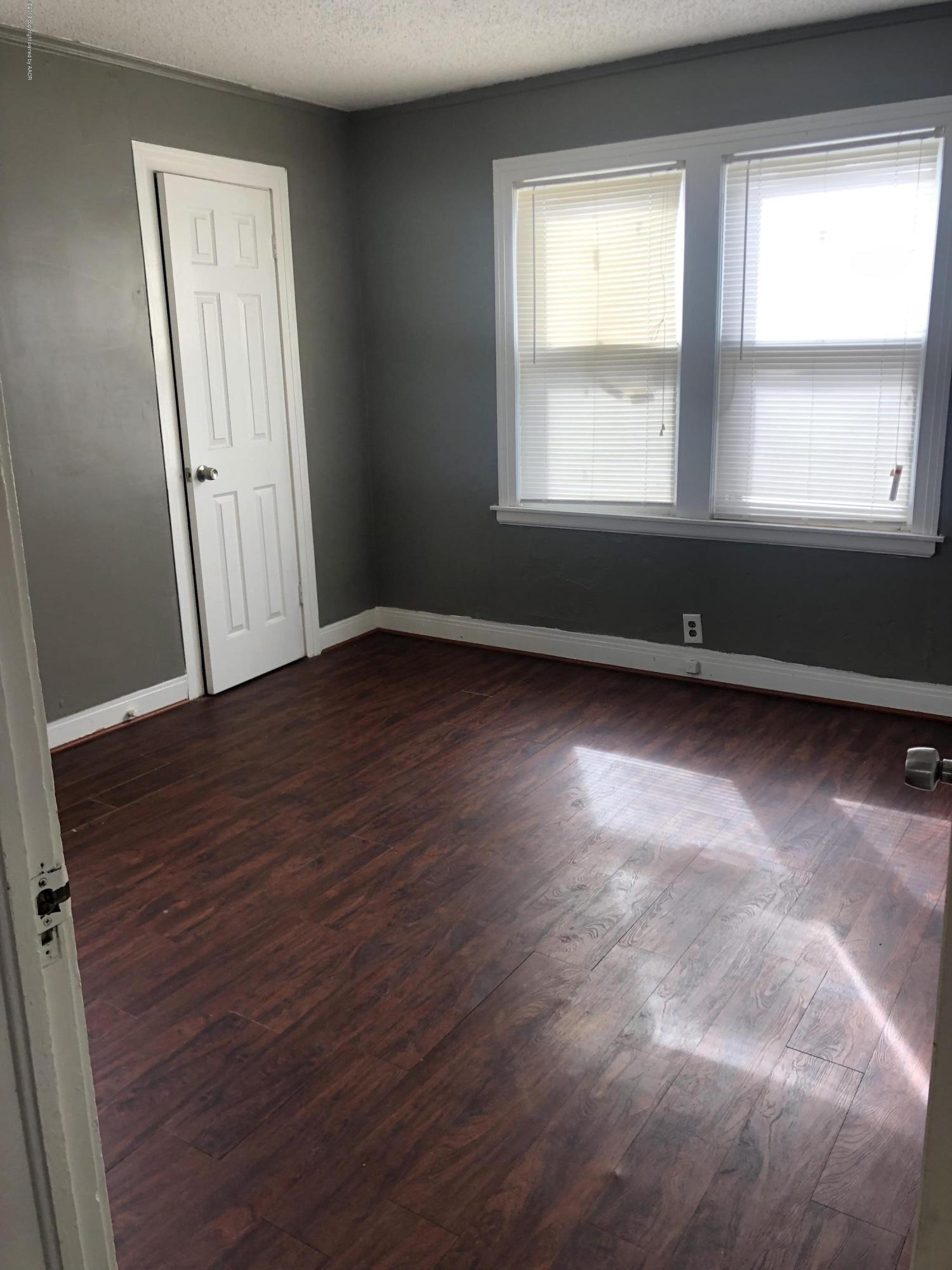 3531-3529 South Harrison Street Amarillo, TX 79110 - Photo 4 of 30 an empty room with wooden floor and windows