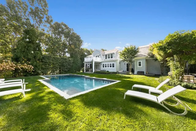 a view of a house with swimming pool and a yard