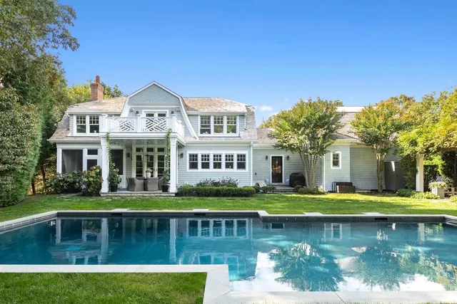 a front view of a house with swimming pool having outdoor seating