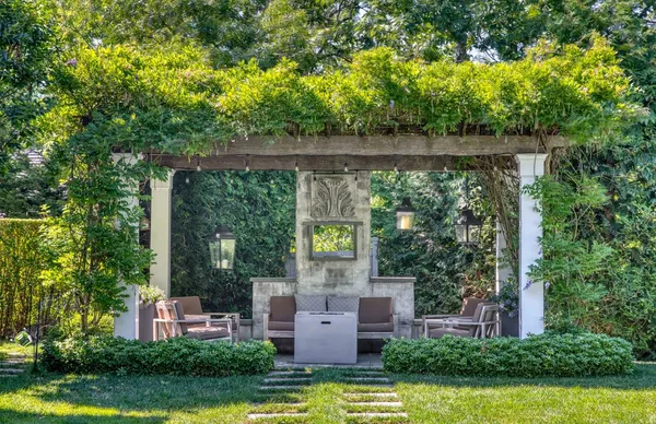 a view of a patio with couches table and chairs potted plants and large tree