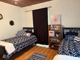 a bedroom with a bed painting on wall and a window