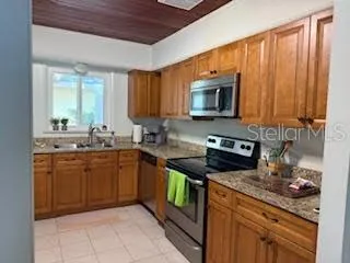 a kitchen with stainless steel appliances granite countertop wooden cabinets a stove top oven a sink and dishwasher
