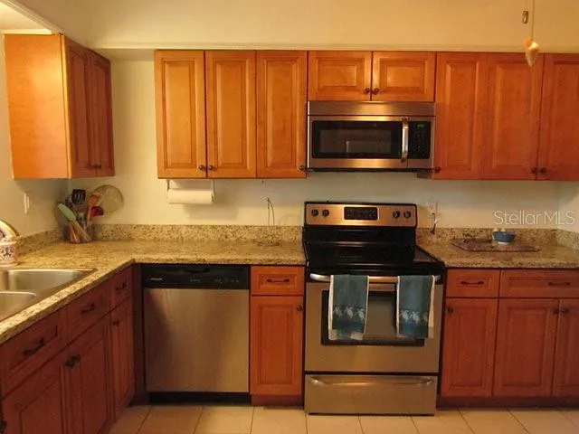 a kitchen with stainless steel appliances granite countertop a stove microwave and sink