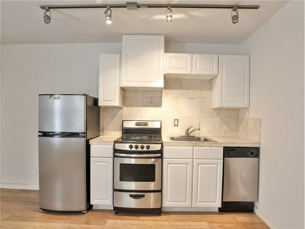 a kitchen with a stove refrigerator and cabinets