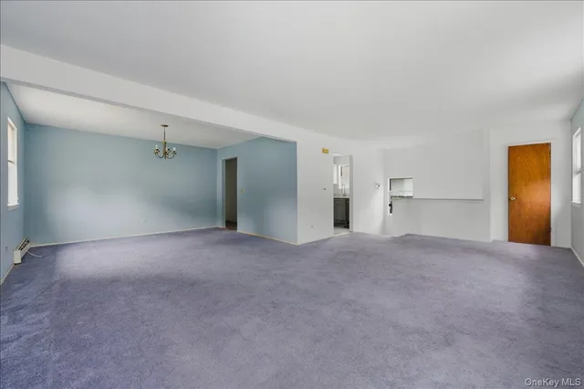 a view of empty room with a kitchen