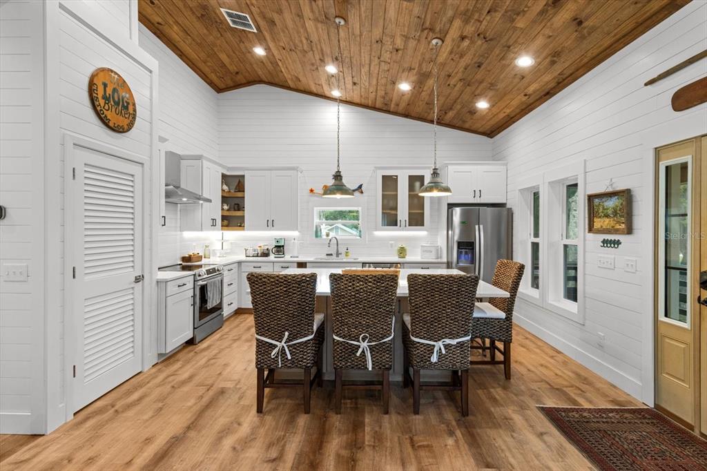 5328 Riverside Drive Yankeetown, FL 34498 - Photo 12 of 46 a dining room with stainless steel appliances kitchen island granite countertop a dining table chairs and a refrigerator
