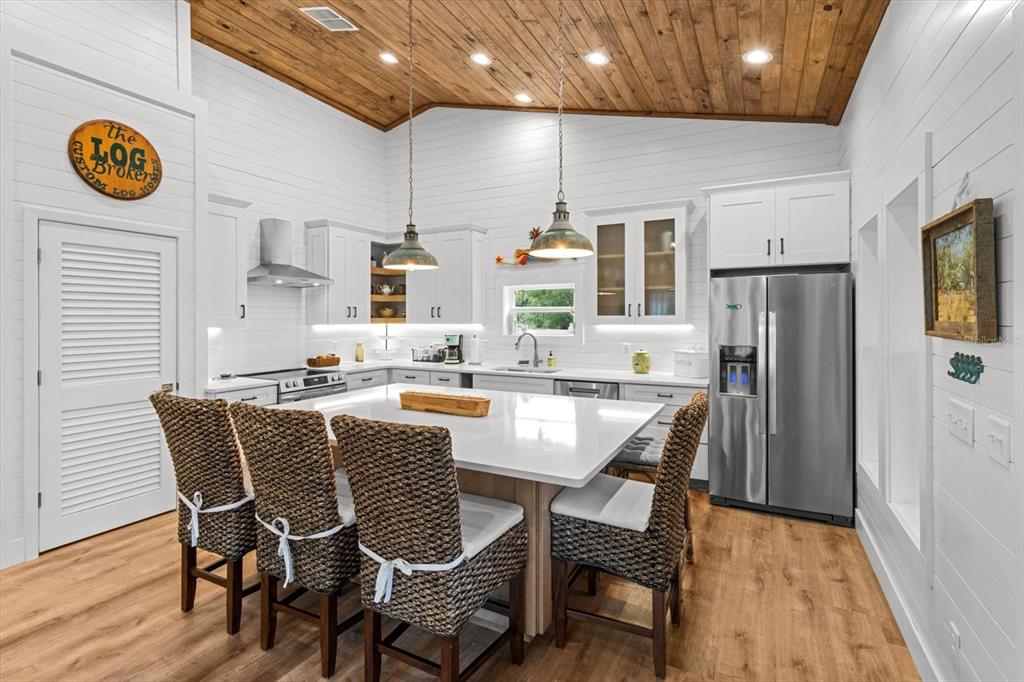 5328 Riverside Drive Yankeetown, FL 34498 - Photo 13 of 46 a dining room with stainless steel appliances kitchen island granite countertop a dining table chairs and a refrigerator