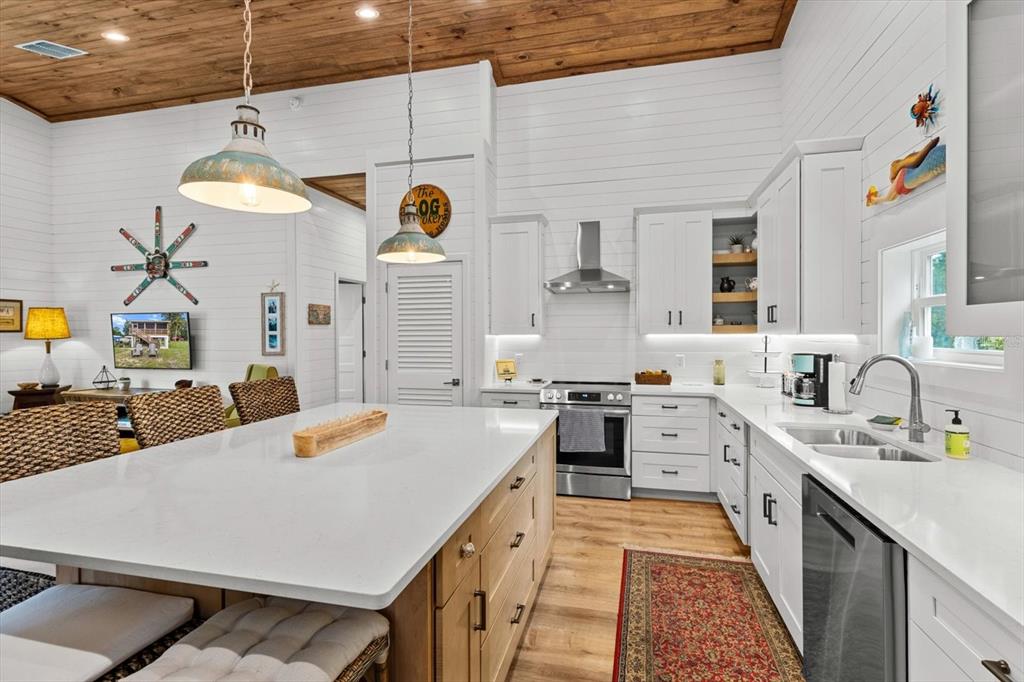 5328 Riverside Drive Yankeetown, FL 34498 - Photo 14 of 46 a large kitchen with kitchen island a stove a sink a center island and a wooden floor