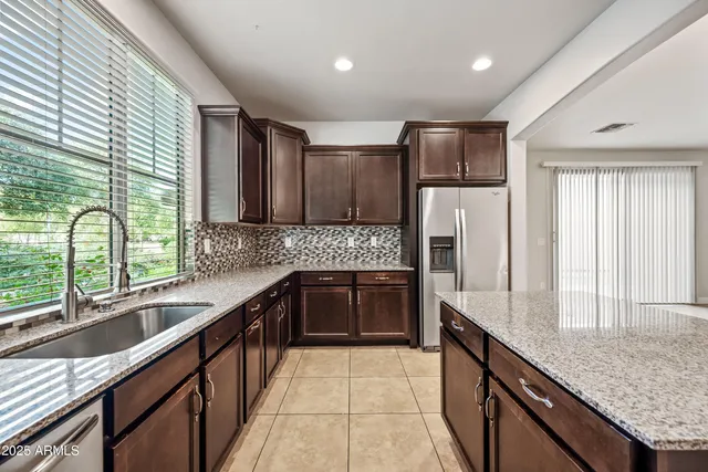 a large kitchen with granite countertop a sink and a stove