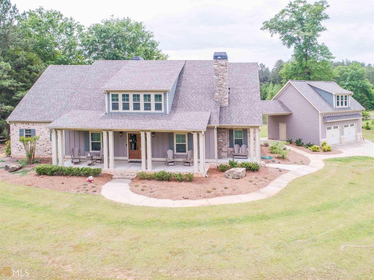 a front view of a house with swimming pool and furniture