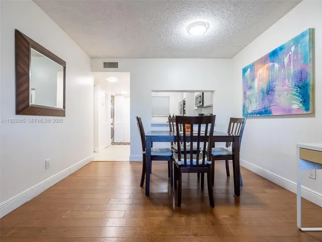 a view of a a dining room with furniture window and wooden floor