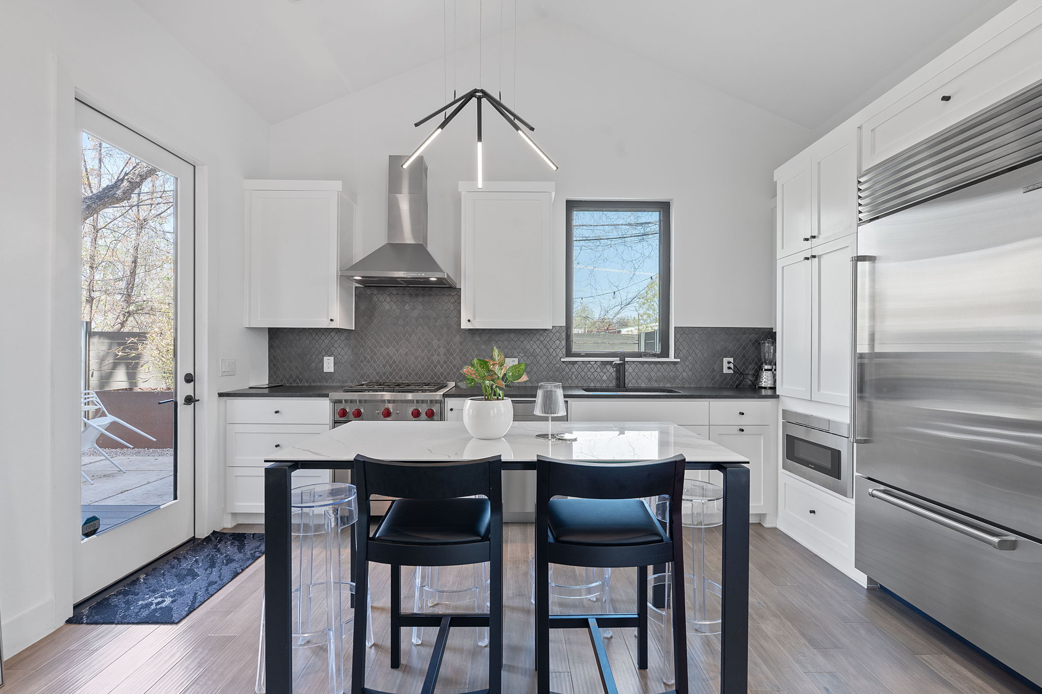 308 Onion Street Austin, TX 78702 - Photo 9 of 40 a kitchen with stainless steel appliances kitchen island granite countertop a table chairs stove and refrigerator